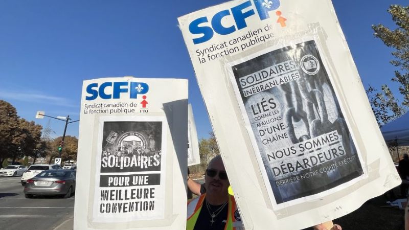 At a rally, someone holds two French signs: "Solidaires pour une meilleure convention" and "Nous sommes débarqués.